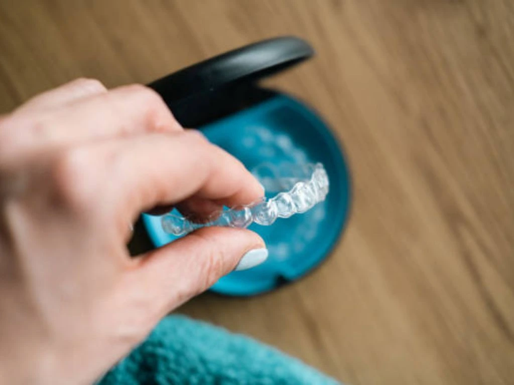 Clear aligners on a soft surface, showcasing the journey to a straighter smile with a focus on comfort and proper oral hygiene