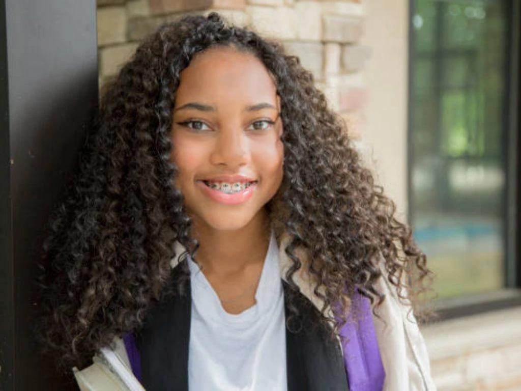 Young girl smiling with braces showcasing a happy orthodontic experience for kids